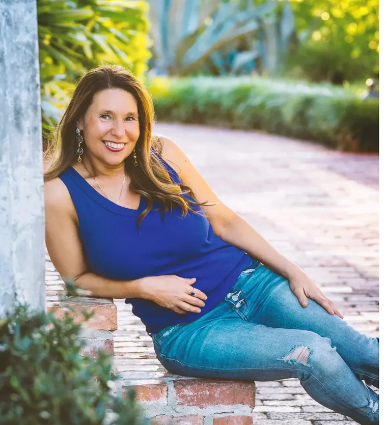 Allison Carmany smiling in a garden, in a portrait photograph