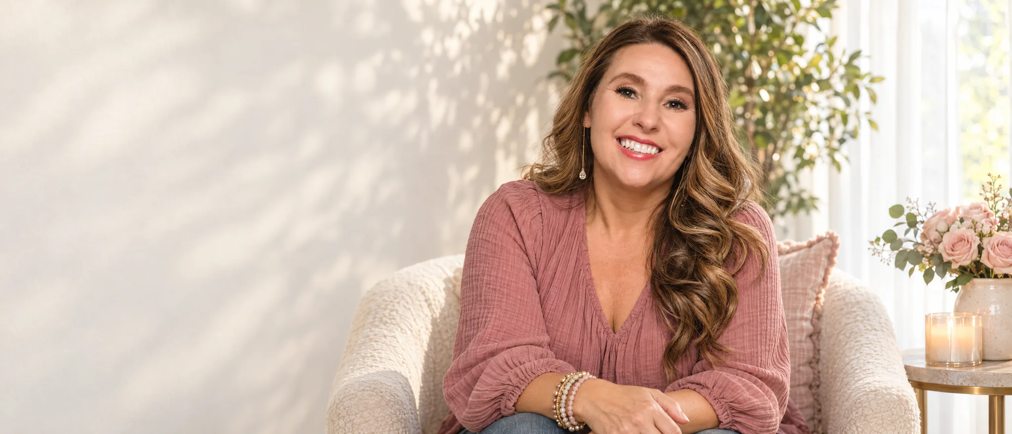 Allison Carmany in a rose blouse, smiling in a warm studio